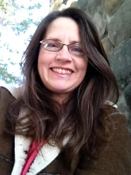 Sheri Jo Posselt smiling outdoors beside a rock formation